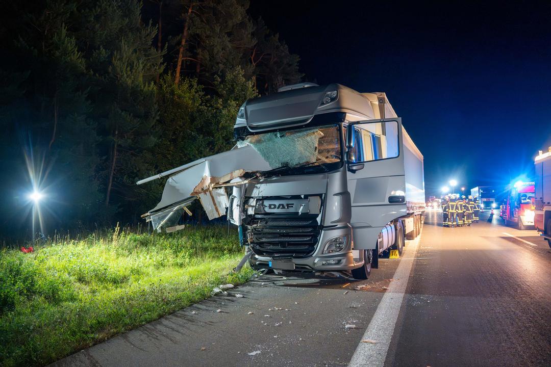 Ein LKW mit zerstörter Front steht auf dem Standstreifen der A9, im Hintergrund sind Rettungskräfte auf der Fahrbahn.