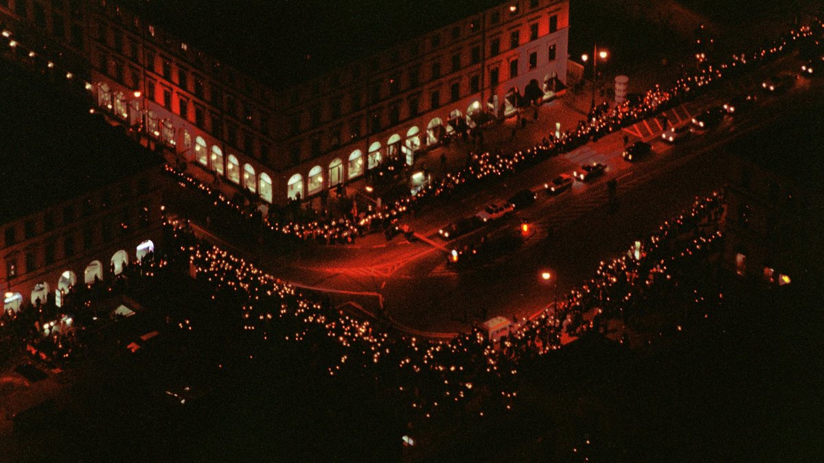 Luftaufnahme einer Demonstration in Form einer Lichterkette aus Kerzen in München.