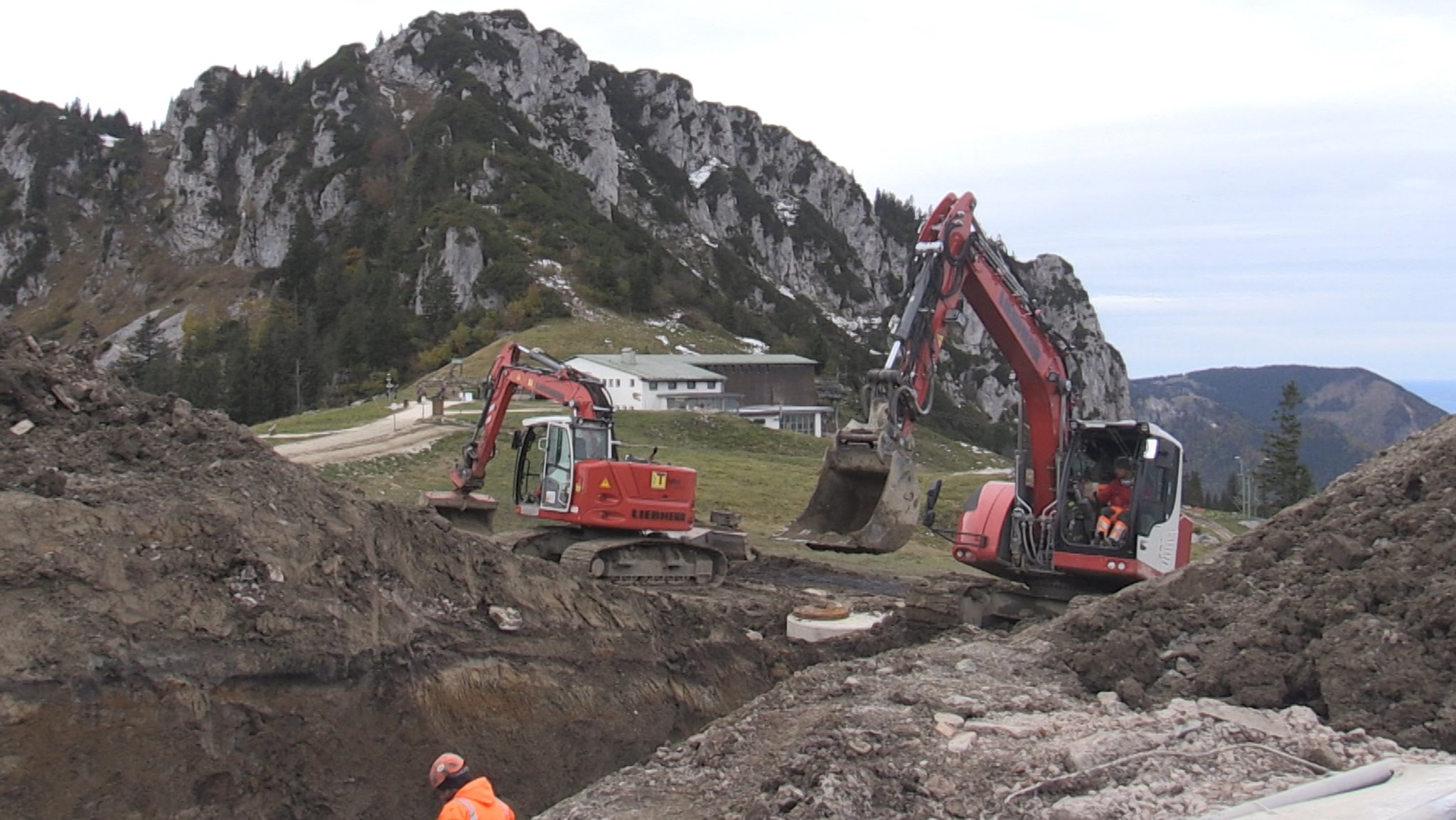 Bagger vor der Kulisse der felsigen Kampenwand