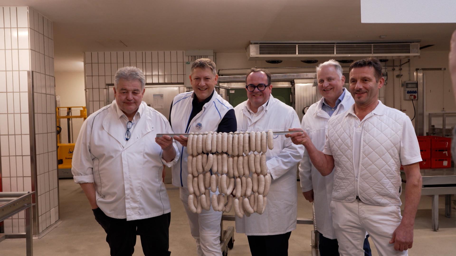 Metzgermeister - unter ihnen Andreas Gaßner (2.v.l.), Obermeister der Münchner Innung, und Werner Braun, stellvertretender Landesinnungsmeister (l.) - mit Weißwürsten bei der Weißwurstprüfung