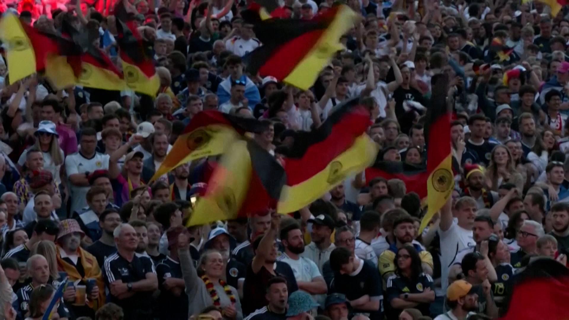Feiernde Fußballfans schwenken im Stadion Deutschland-Fahnen
