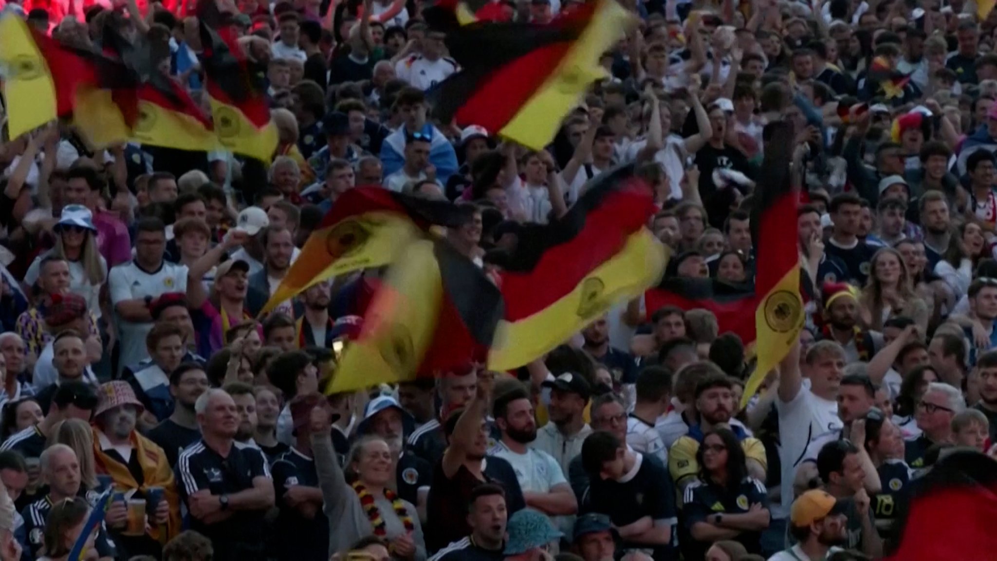 Feiernde Fußballfans schwenken im Stadion Deutschland-Fahnen