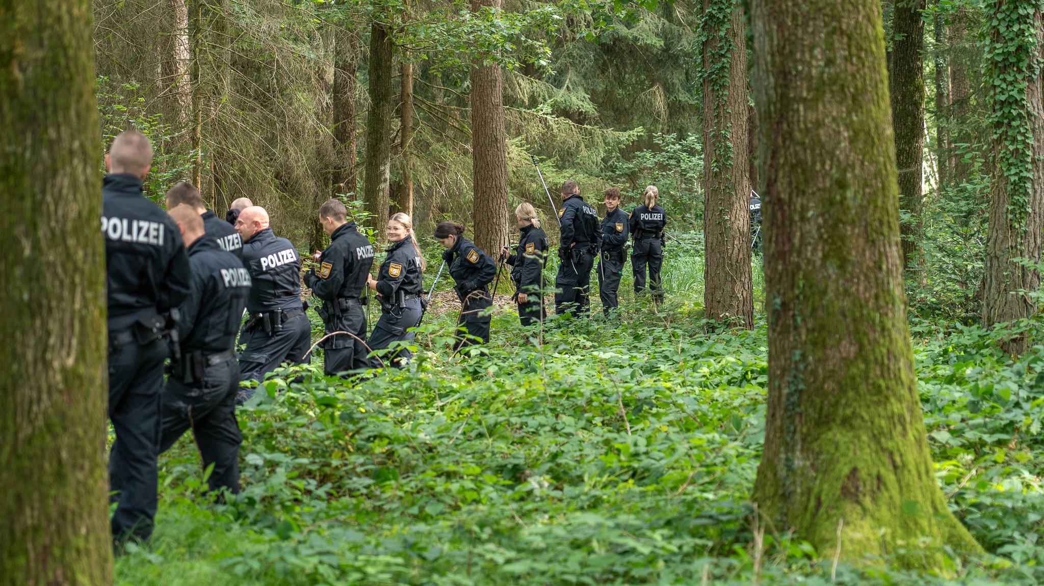 Polizistinnen und Polizisten im Wald. 