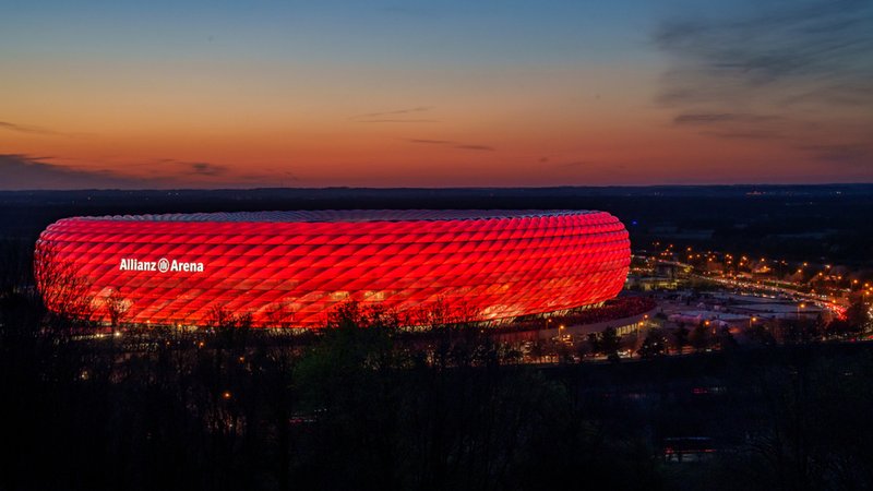 Die rot leuchtende Allianz Arena in der Abenddämmerung. | Bild: stock.adobe.com/Sandra Alkado Die rot leuchtende Allianz Arena in der Abenddämmerung.