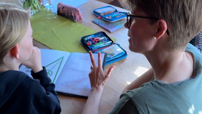 Lisa und ihr Sohn Philipp rechnen den Notenschnitt aus, den er im Übertrittszeugnis haben wird. | Bild: BR/ Carolin Hasenauer Lisa und ihr Sohn Philipp rechnen den Notenschnitt aus, den er im Übertrittszeugnis haben wird.