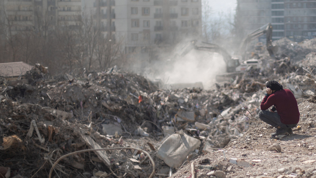 Ein Mann blickt auf die Trümmer nach dem Erdbeben.
