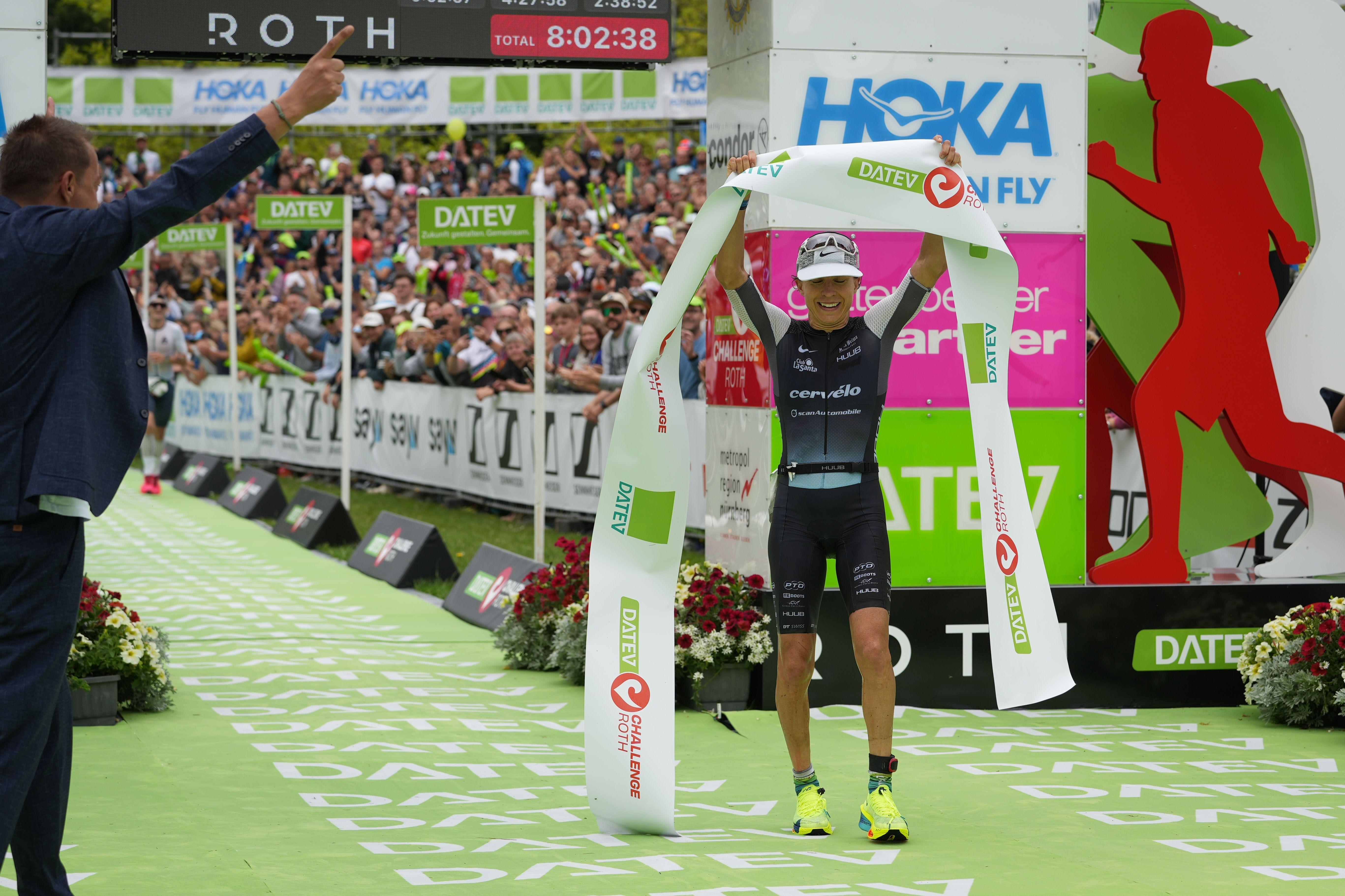 Anne Haug hält das Zielbanner des Challenge Roth 2024 in Händen.