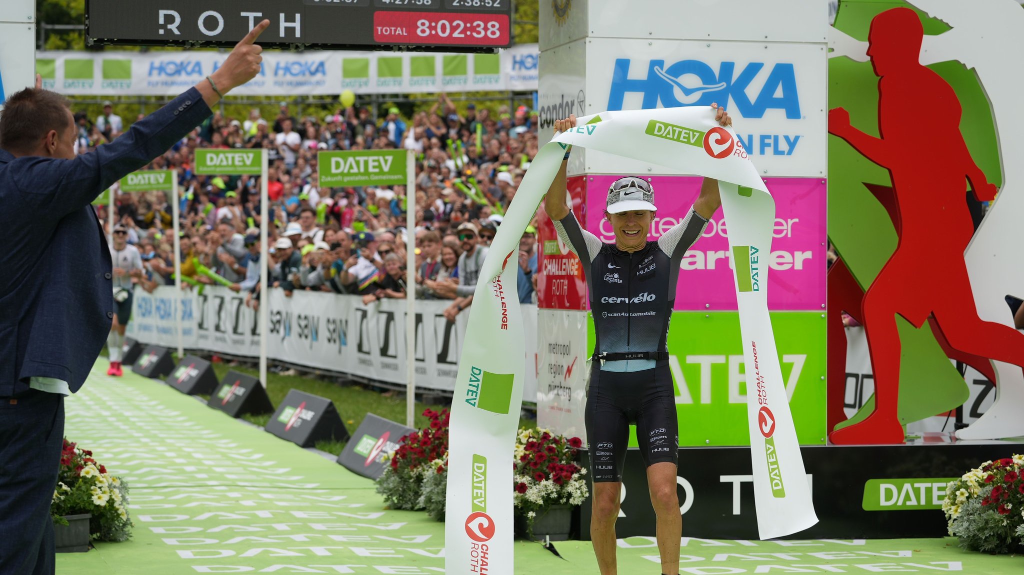 Anne Haug hält das Zielbanner des Challenge Roth 2024 in Händen.