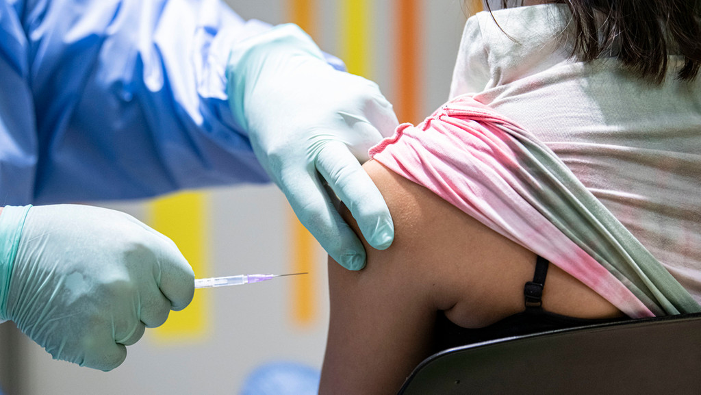 Eine Person verabreicht einer Frau eine Corona-Schutzimpfung (Symbolbild).