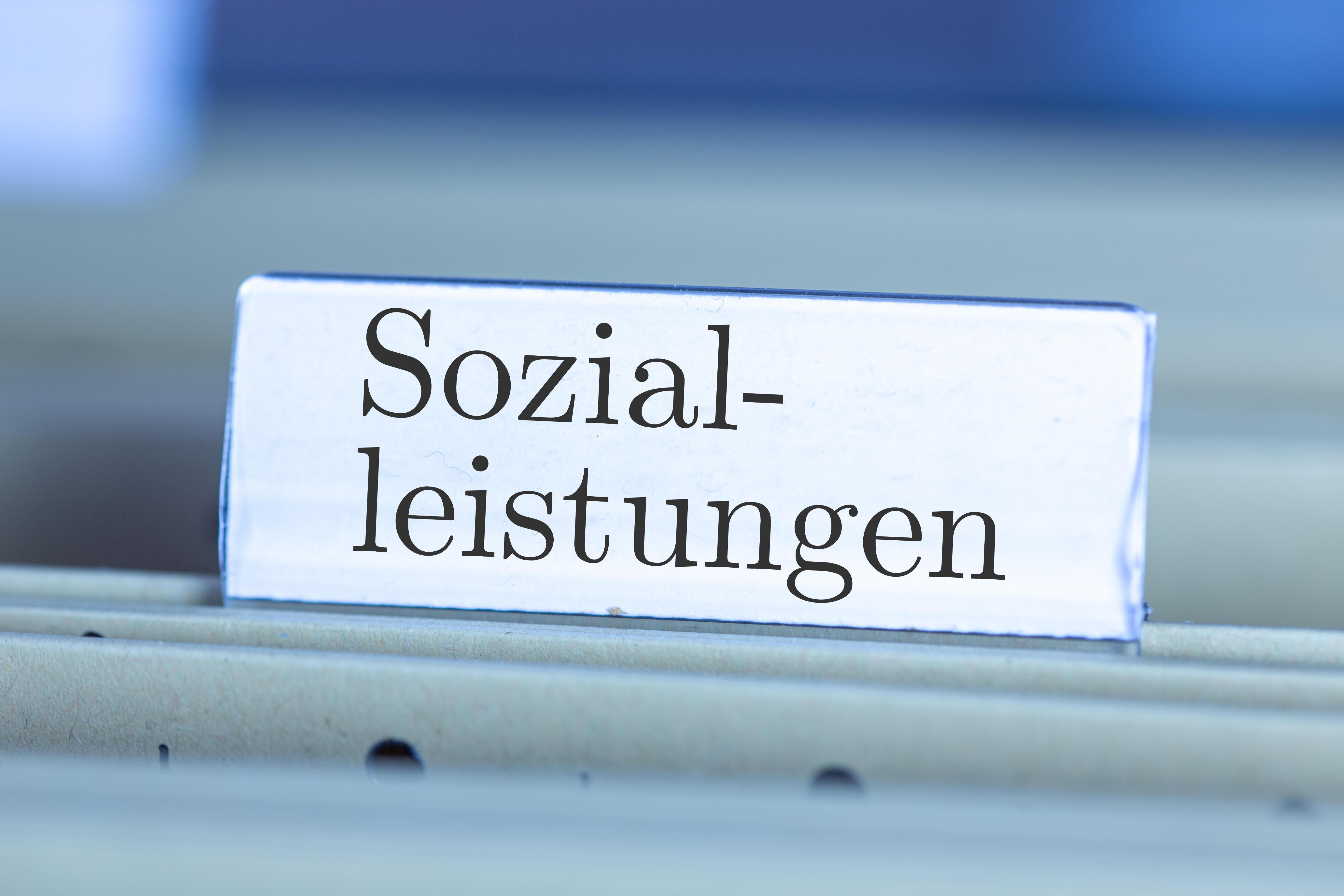  (Symbolbild) Schild mit der Aufschrift "Sozialleistungen" an einem Hängemappenregister