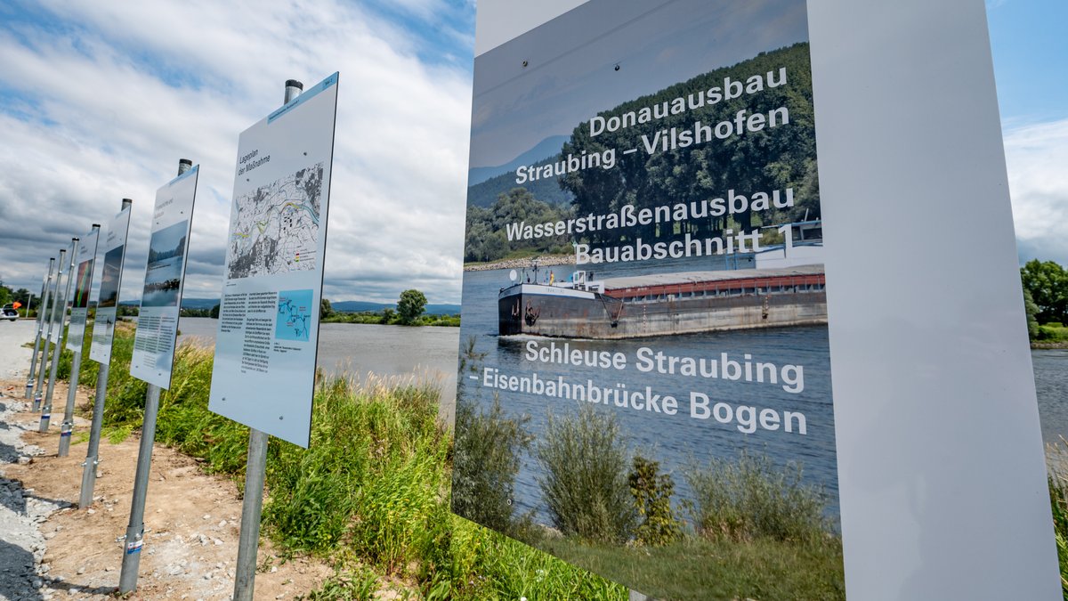 Ein Schild mit der Aufschrift "Donauausbau - Straubing-Vilshofen" steht am Ufer der Donau