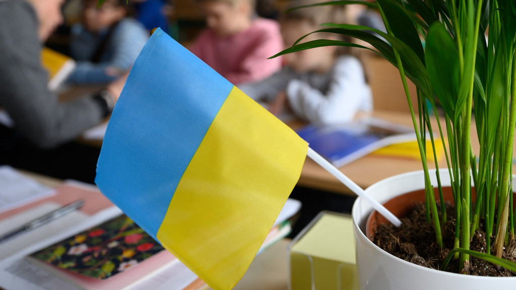 Eine ukrainische Fahne und Kinder im Hintergrund