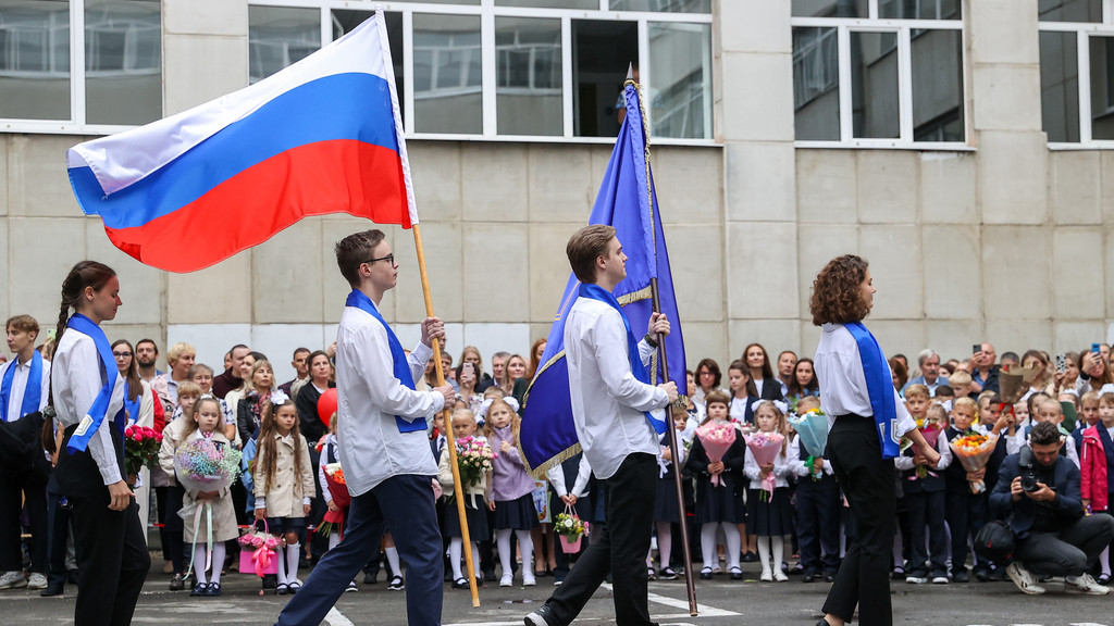 Junge Menschen in weißen Hemden mit Russland-Flagge