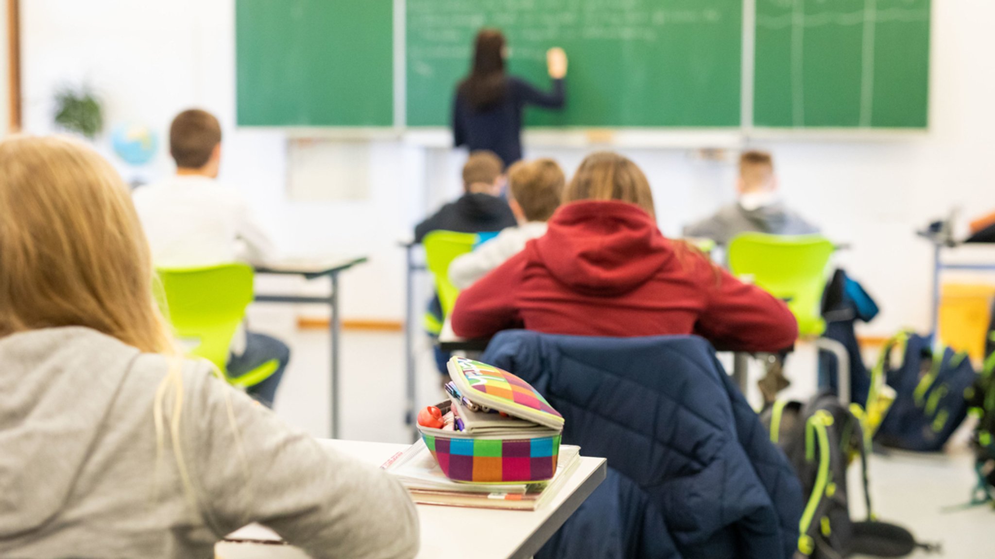 Schülerinnen und Schüler einer fünften Klasse einer Realschule sitzen während des Unterrichts in ihrem Klassenzimmer.