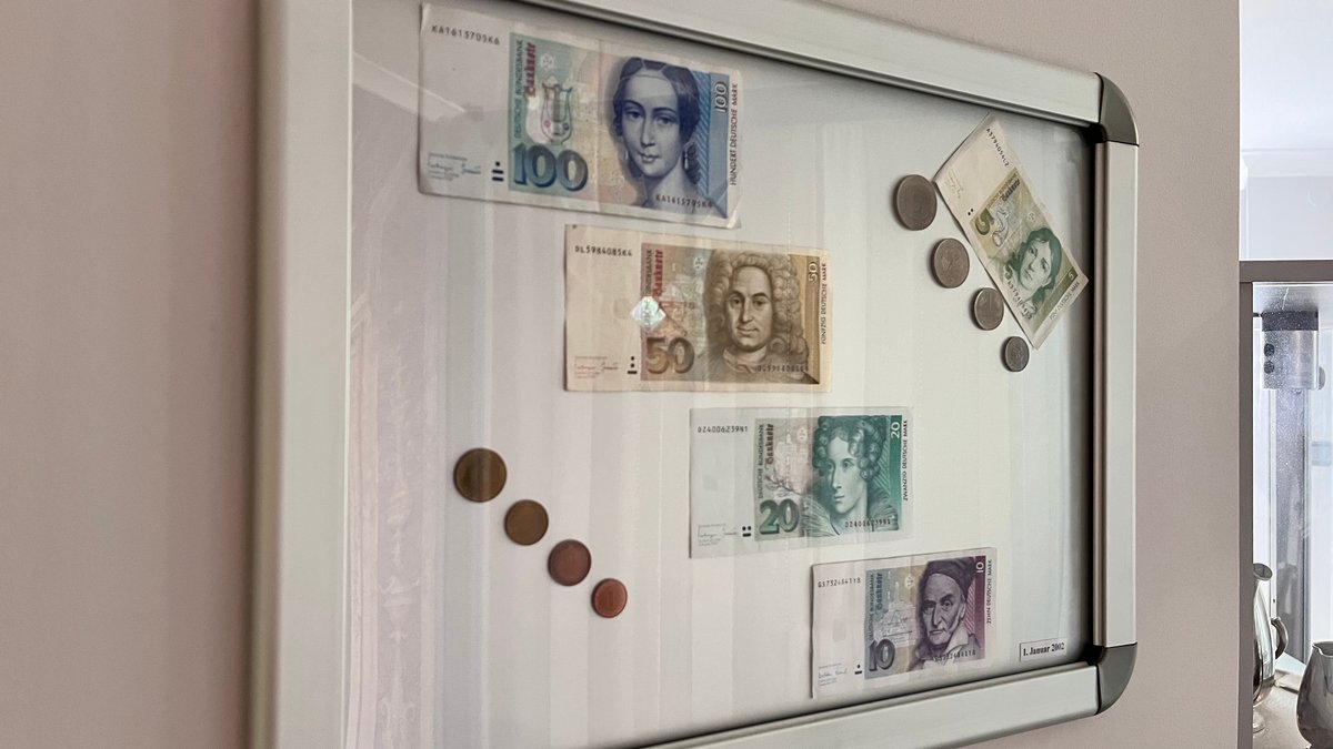 Jürgen R. aus München hat in seinem Hausgang einen Bilderrahmen mit alten Münzen und D-Mark-Scheinen.