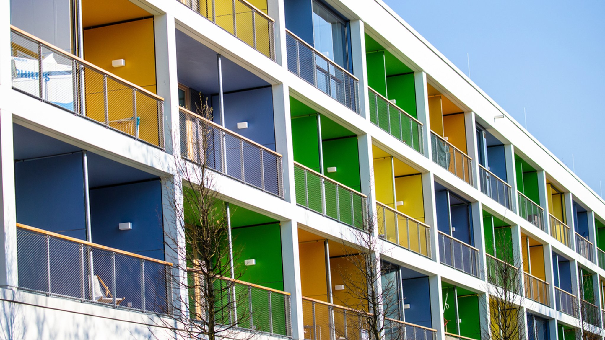 Bunte Hausfassade mit überdachten Balkonen.