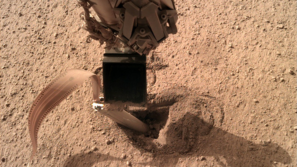 Schaufel des Roboterarms des NASA-Mars-Roboters InSight drückt auf die Hinterkante des deutschen Mars-Maulwurfs, den Bohrer HP3