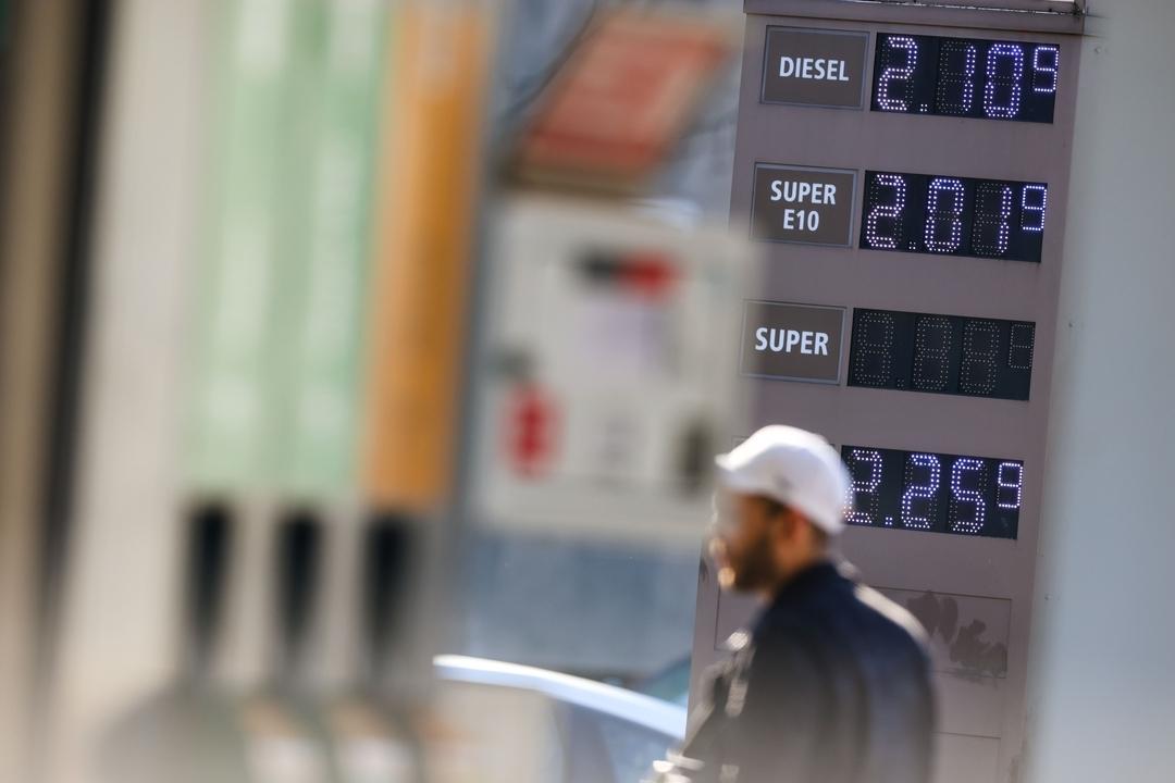 (Symbolbild) Ein Mann läuft an einem Preismasten einer Tankstelle vorbei