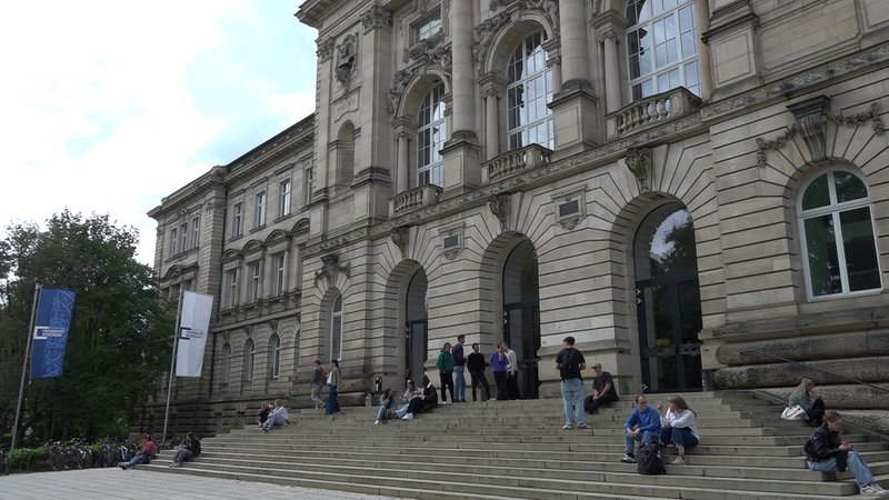 Studierende halten sich auf der Treppe eines Gebäudes der Universität Würzburg auf | Bild: BR Studierende halten sich auf der Treppe eines Gebäudes der Universität Würzburg auf