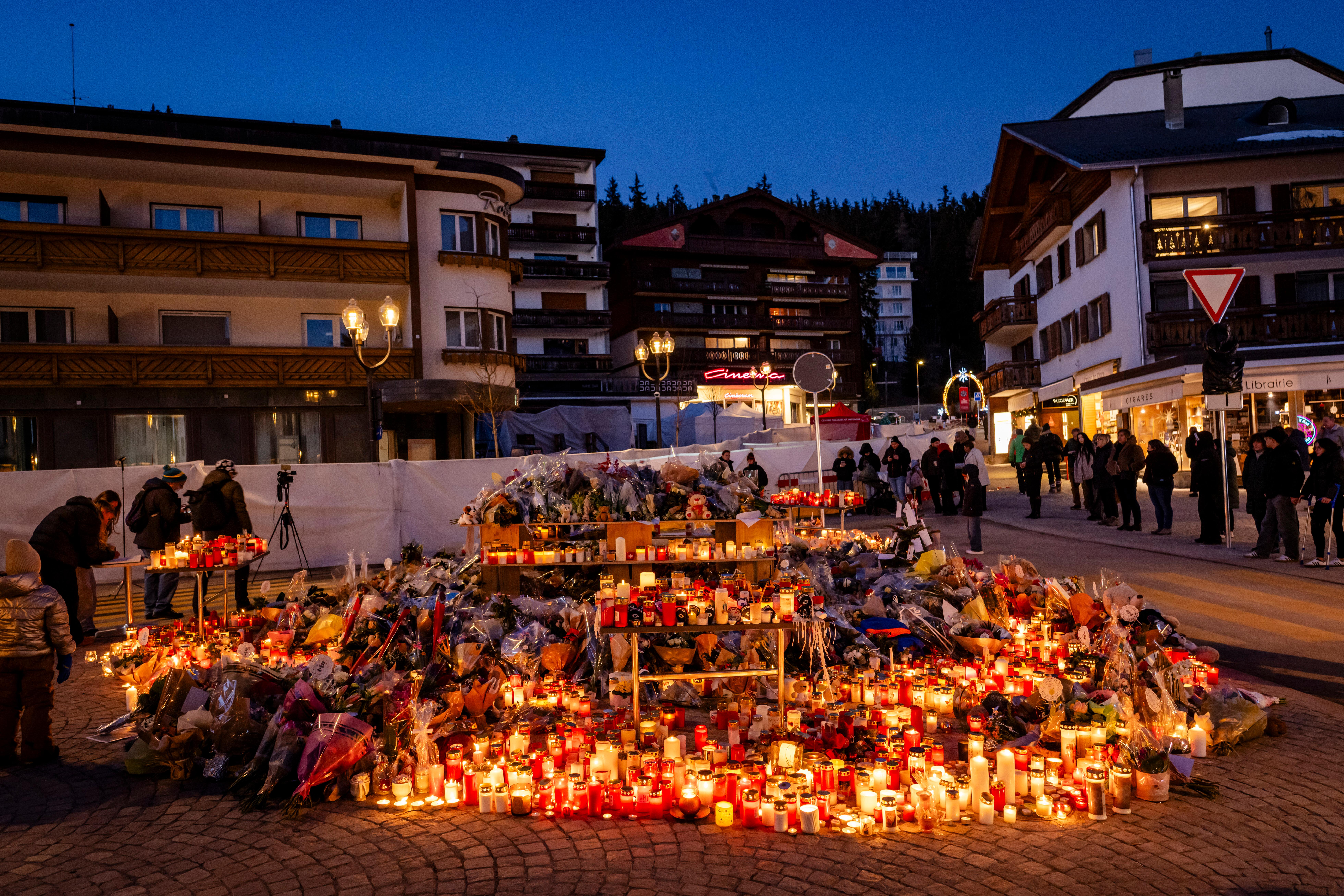 Blumen und Kerzen sind als Gedenken an die Opfer nach dem Brand in der Bar und Lounge "Le Constellation" in Crans-Montana abgelegt.