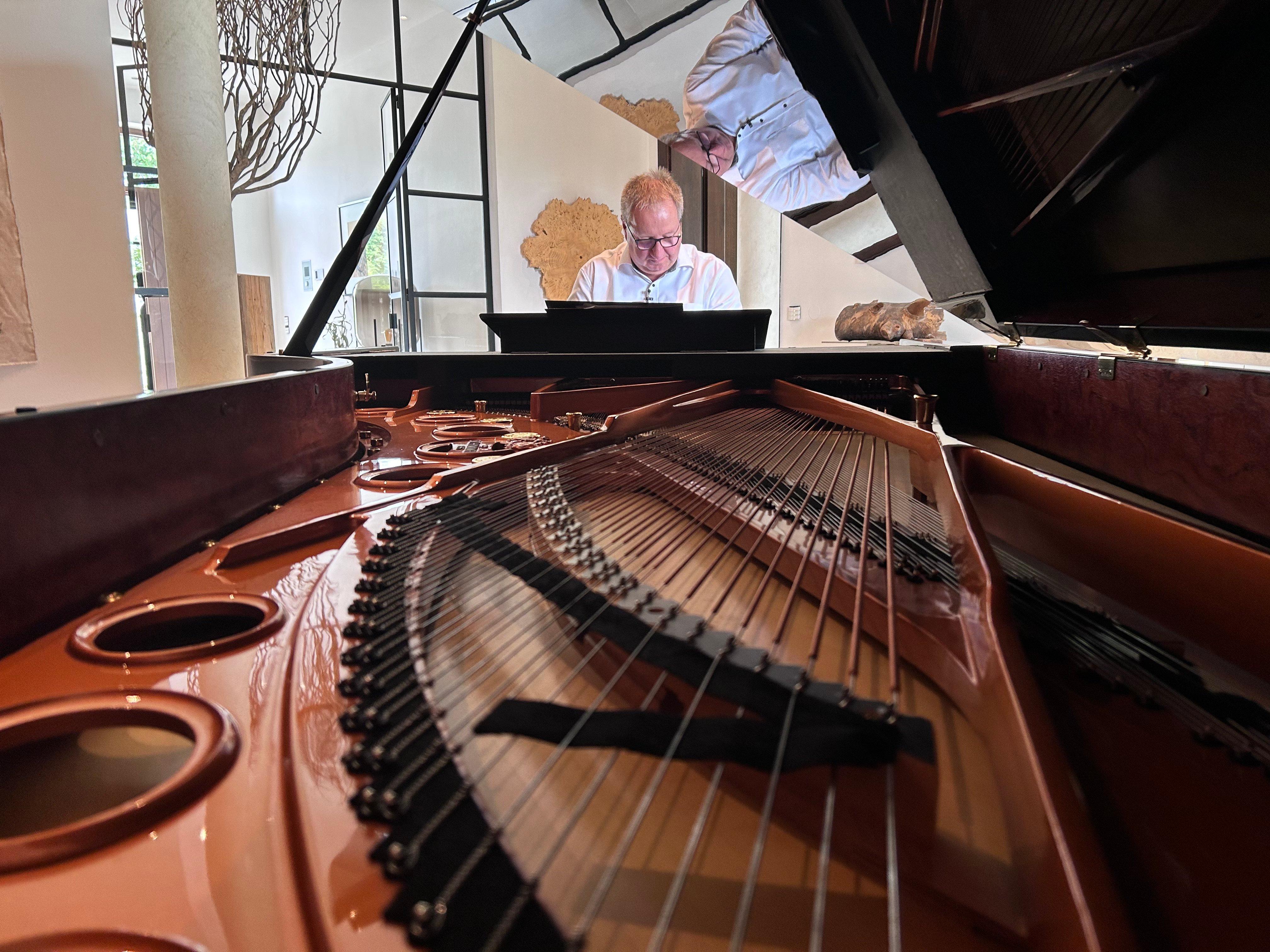 Thomas Hilz spielt auf einem Konzertflügel. 