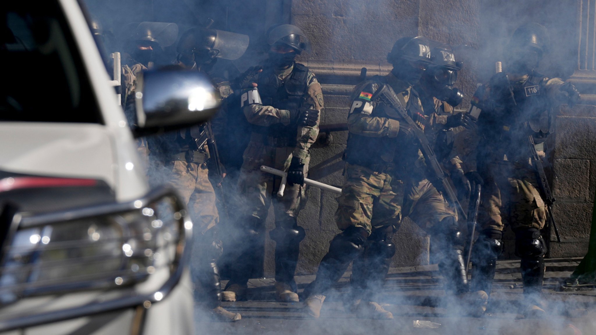 Bolivien, La Paz: Militärpolizisten stehen inmitten von Tränengas, das sie vor dem Präsidentenpalast auf der Plaza Murillo abgefeuert haben. 