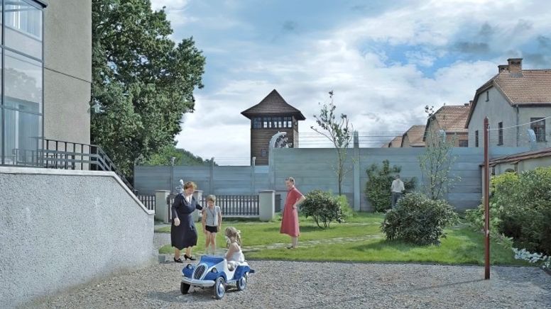 Zwei Frauen und zwei Kinder in einem sauberen Hof, im Hintergund der Wachtturm eines Konzentrationslagers.  | Bild:Bild: Leonine