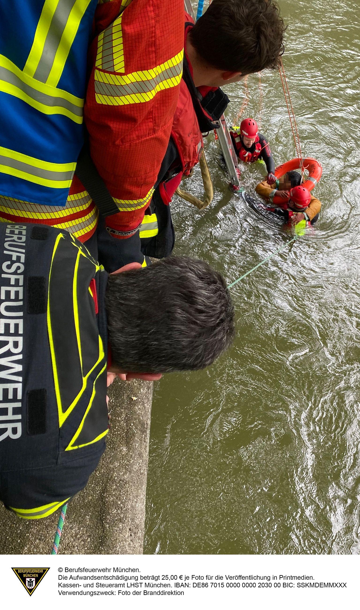 Feuerwehrleute holen eine Frau aus der Isar.