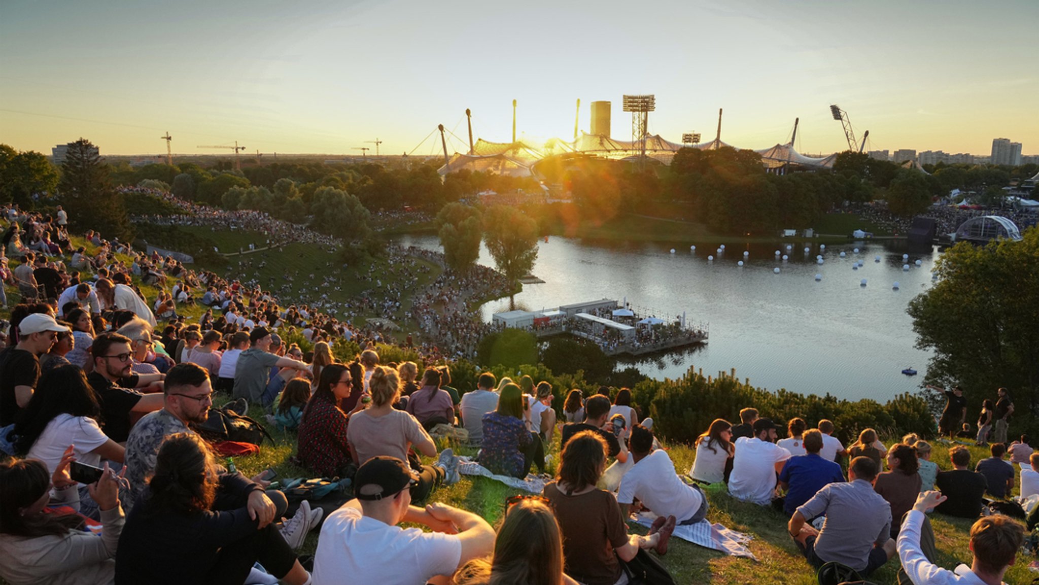 Die Zuschauer verfolgen von einem Berg im Olympiapark die Eröffnung der European Championships 2022.