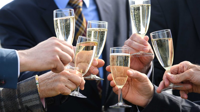 Symbolbild: Menschen im Anzug stoßen mit Champagner an. | Bild: picture alliance/dpa | Robert Michael Symbolbild: Menschen im Anzug stoßen mit Champagner an.