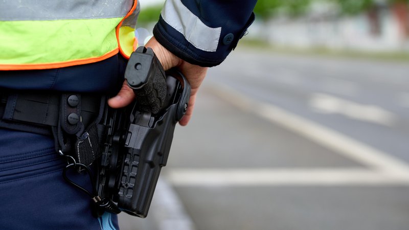 Symbolbild: Polizist hält die Hand an der Waffe | Bild: picture alliance / CHROMORANGE | Michael Bihlmayer Symbolbild: Polizist hält die Hand an der Waffe