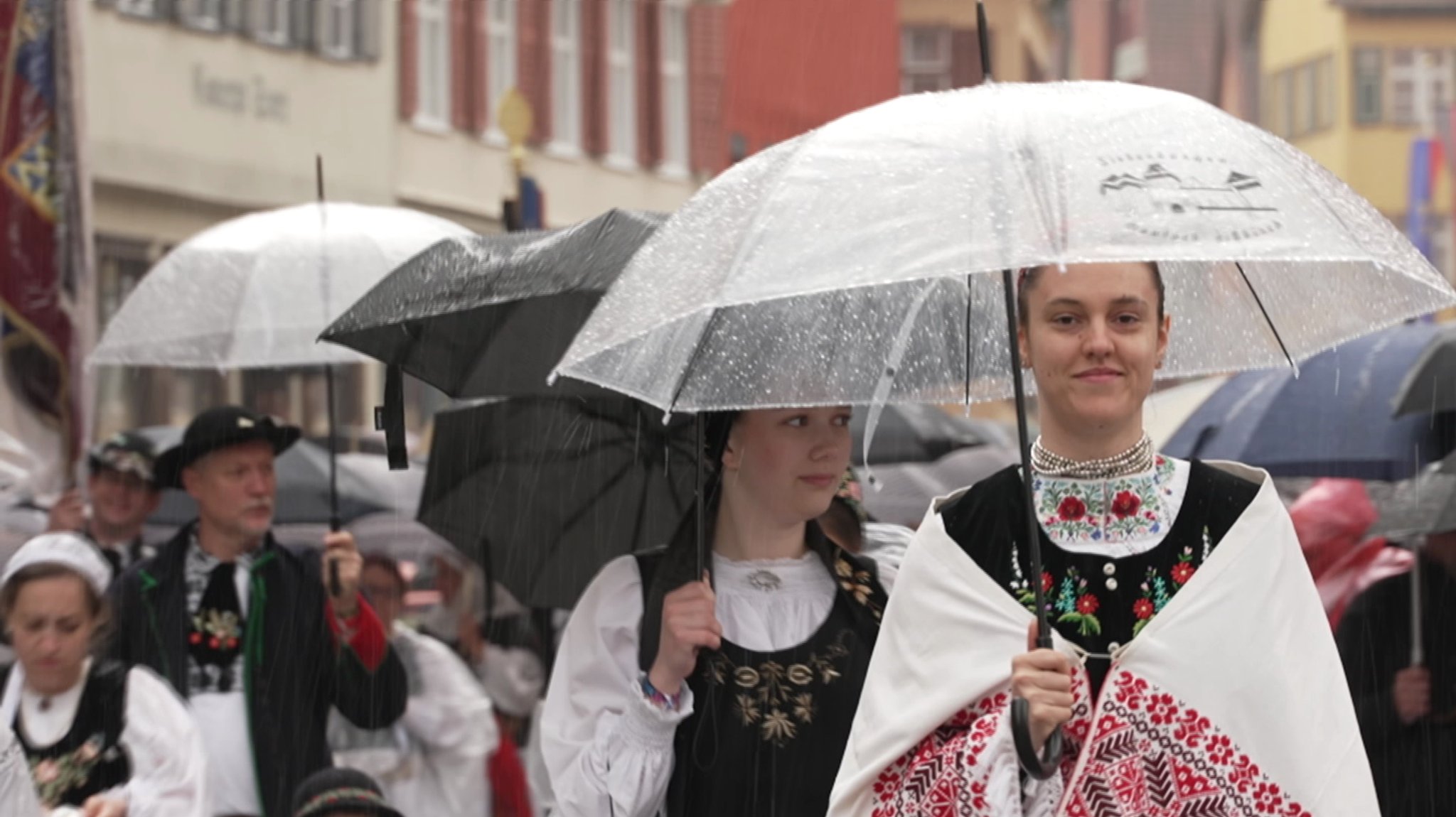 Menschen tragen Tracht und Regenschirme | Bild: BR Menschen tragen Tracht und Regenschirme