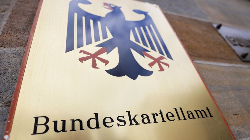 Ein Schild mit Bundesadler hängt vor dem Bundeskartellamt in Bonn^.