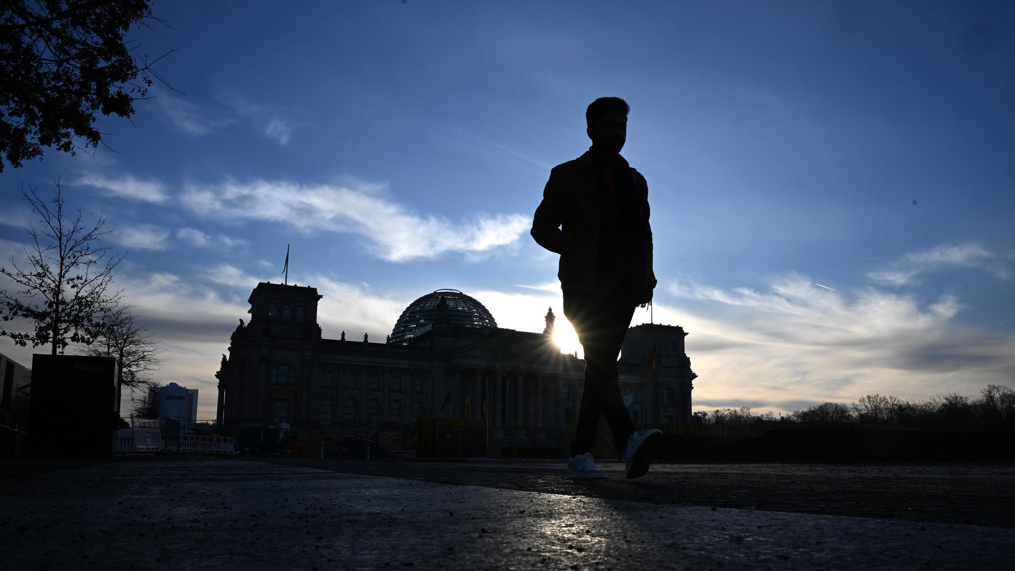 Ein Mann geht am Morgen vor dem Reichstagsgebäude. Am Vortag fand die vorgezogene Wahl zum 21. Deutschen Bundestag statt.