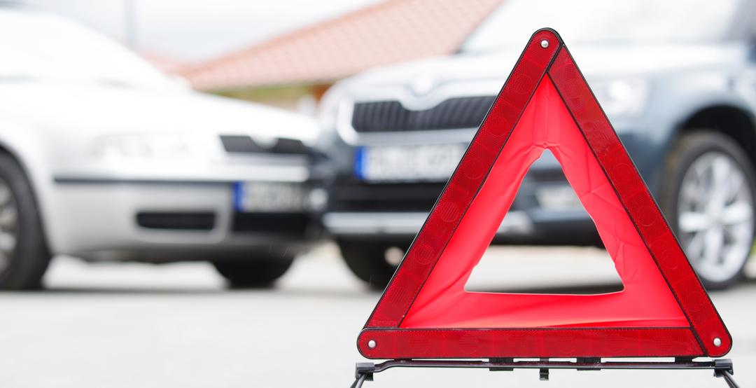 Ein aufgestelltes Warndreieck warnt vor einer Unfallstelle.