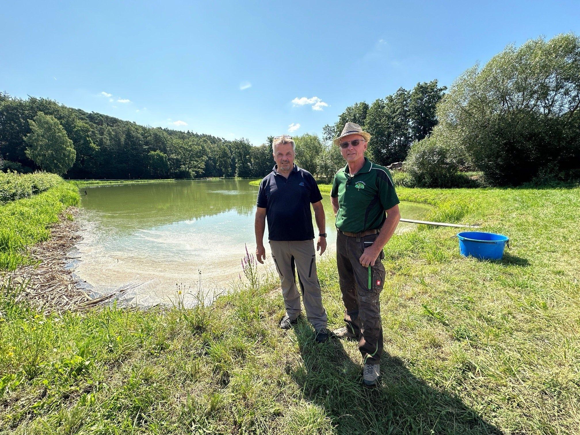 Zwei Männer stehen vor einem Karpfenteich im Landkreis Neustadt/Aisch-Bad Windsheim