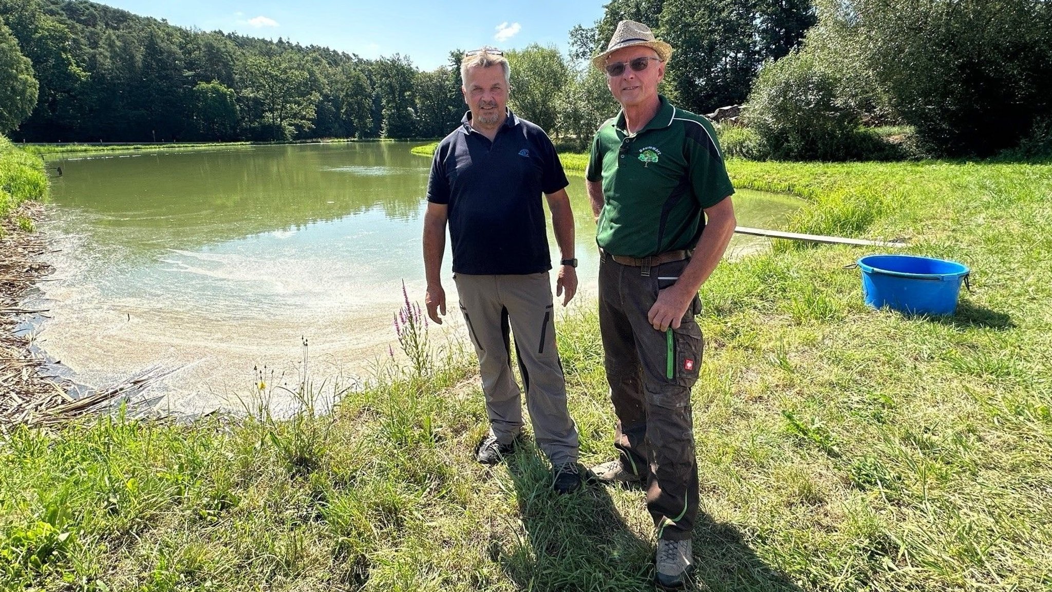 Zwei Männer stehen vor einem Karpfenteich im Landkreis Neustadt/Aisch-Bad Windsheim