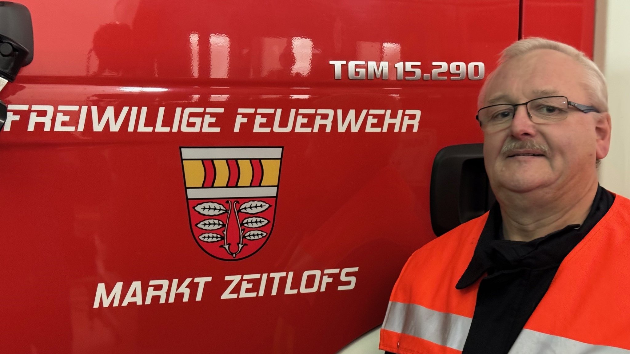 Bernd Buberl vor der Fahrzeugtür eines Feuerwehrautos der Freiwilligen Feuerwehr des Marktes Zeitlofs (Landkreis Bad Kissingen)