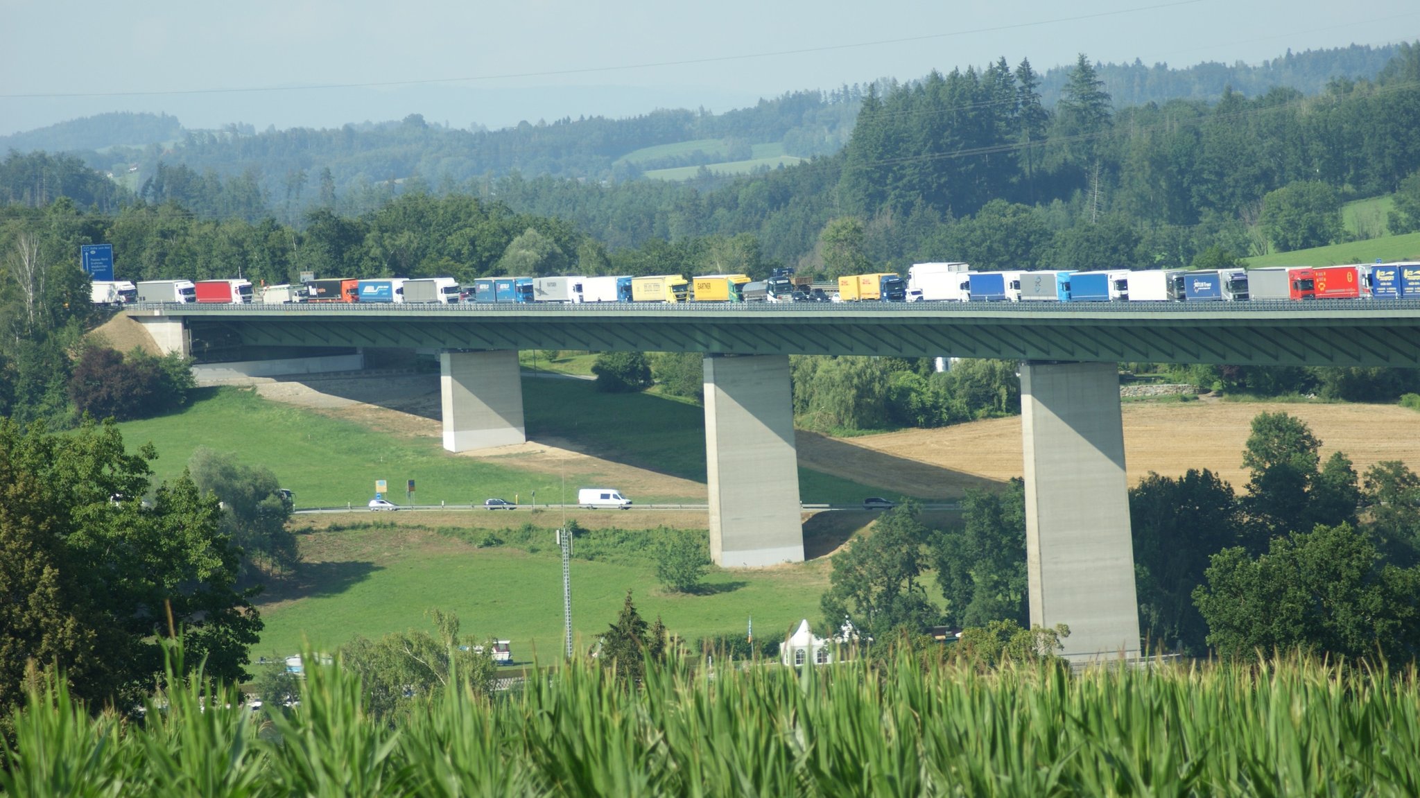 Lkw stehen im Stau auf einer Brücke.