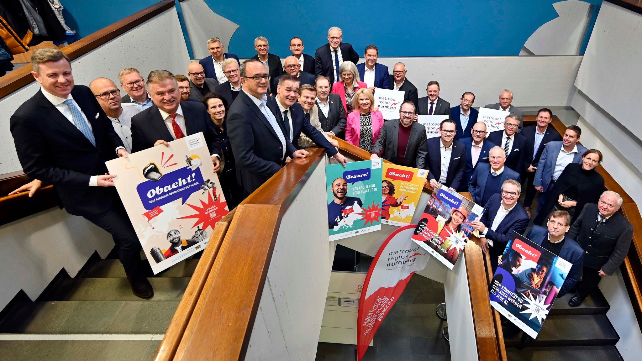 Gruppenbild der Ratsversammlung im Treppenhaus des Erlanger Rathauses