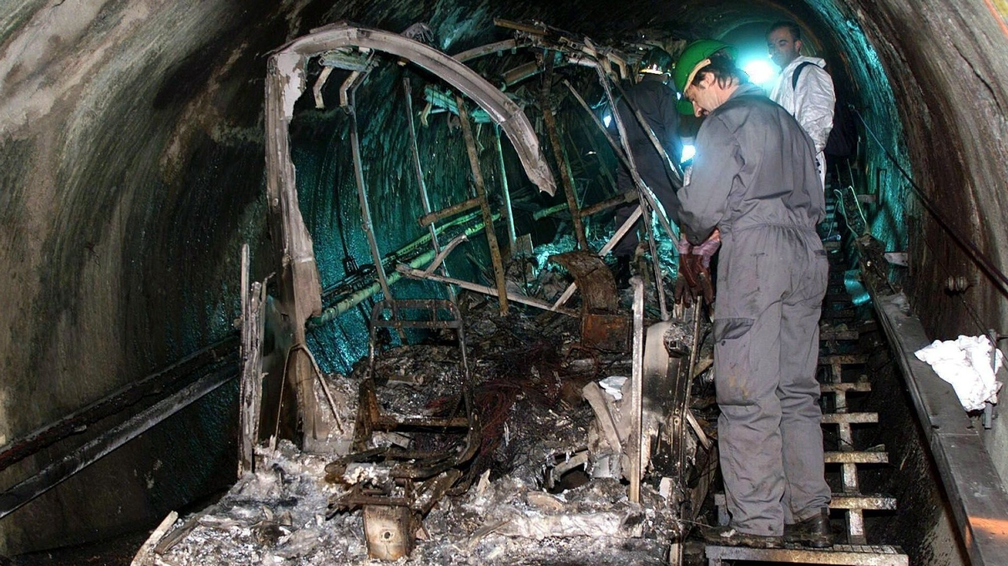 Bergungsarbeiter inspizieren am 16.11.2000 die verbrannten Reste der Gletscherbahn im Tunnel am Kitzsteinhorn.