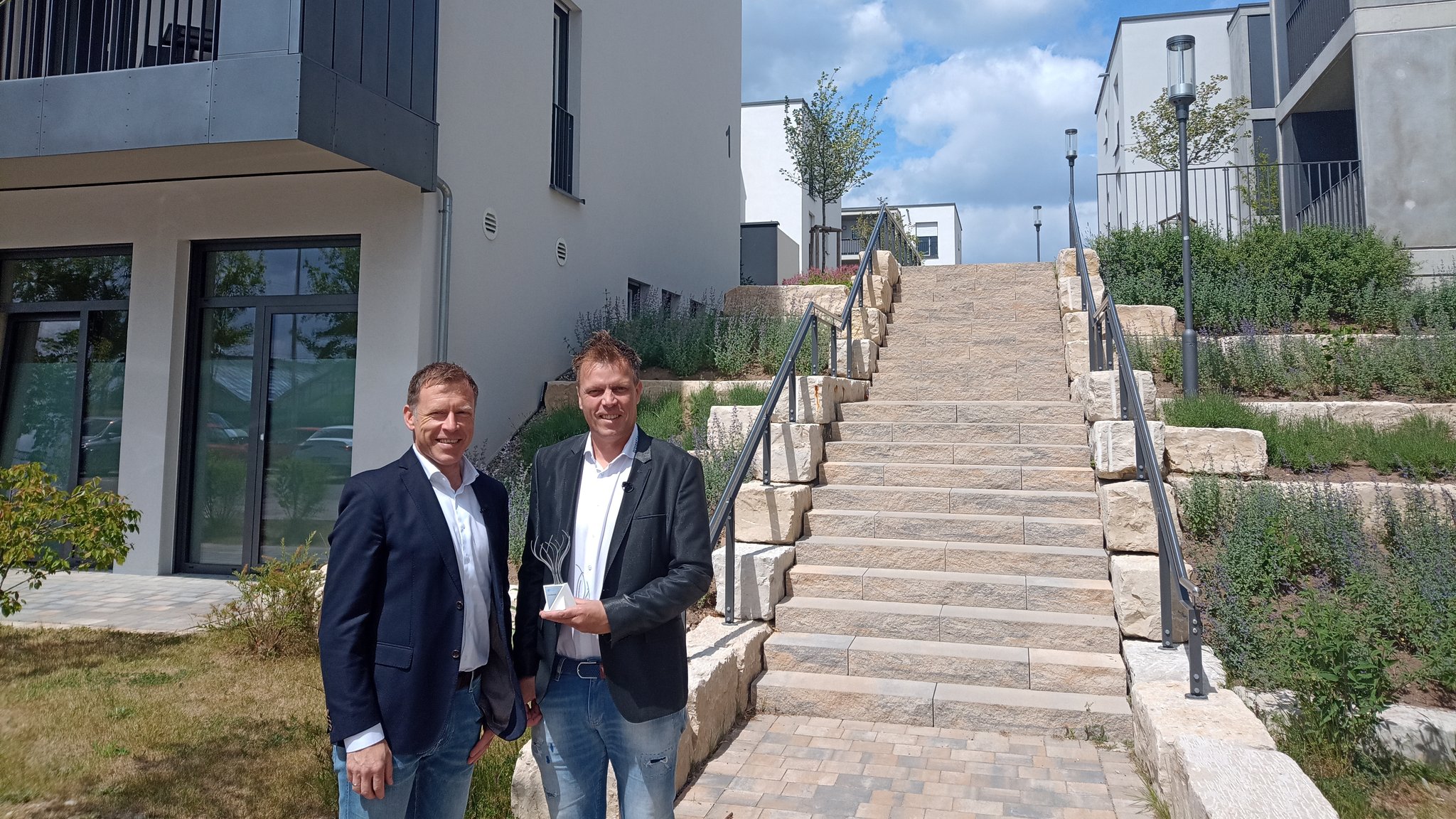 Die beiden Geschäftsführer von "Projekt Bauart" aus Forchheim mit dem Innovationspreis Bayern vor den Nicolaihöfen in Höchstadt an der Aisch.