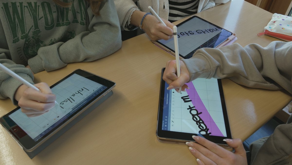 Schüler schreiben auf Tablets im Unterricht