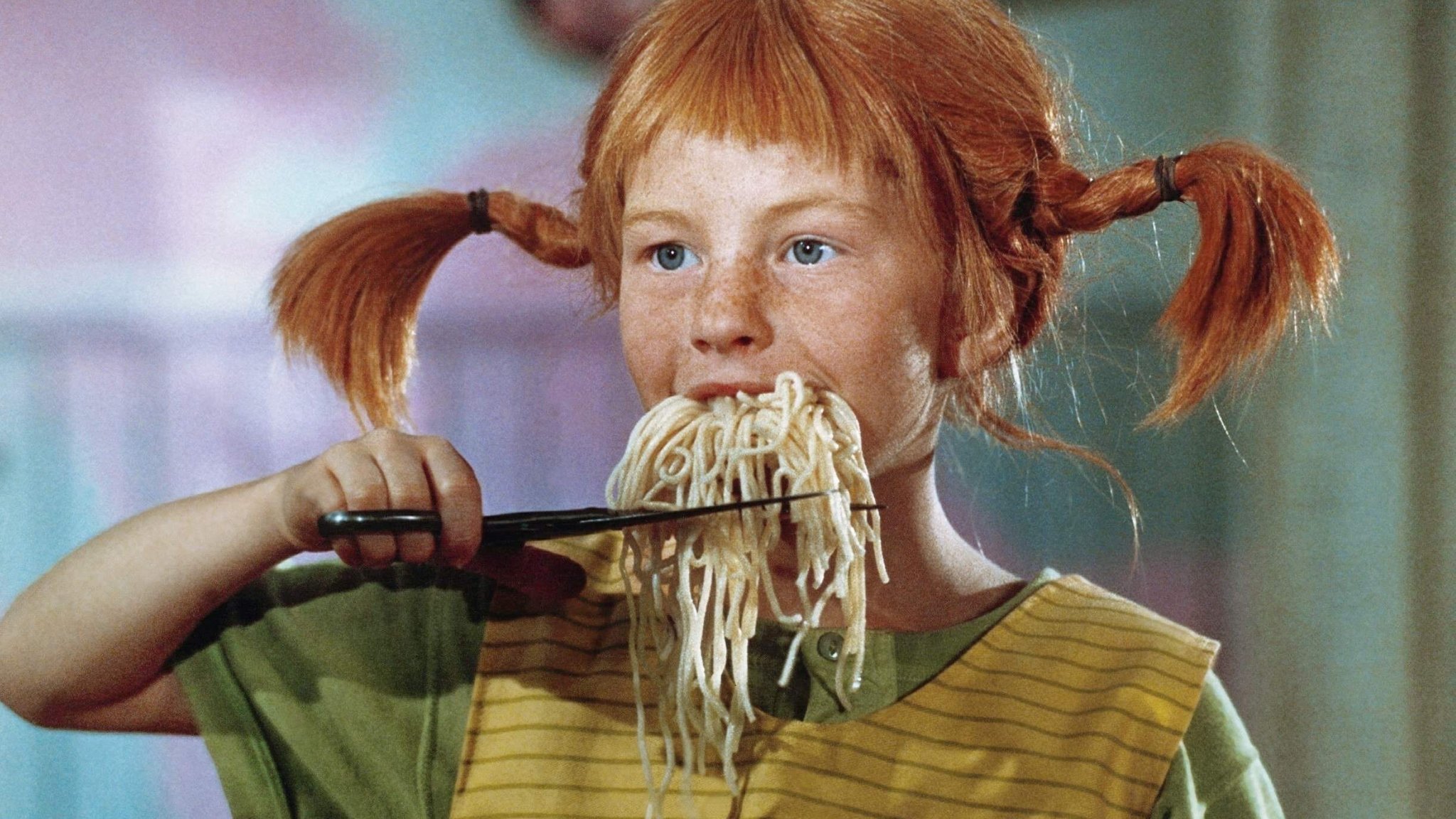 Inger Nilsson schneidet als Pippi Langstrumpf Spaghetti unter ihrem Mund mit der Schere ab, in "Pippi in Taka-Tuka-Land" (S/BRD 1970, Regie: Olle Hellbom)