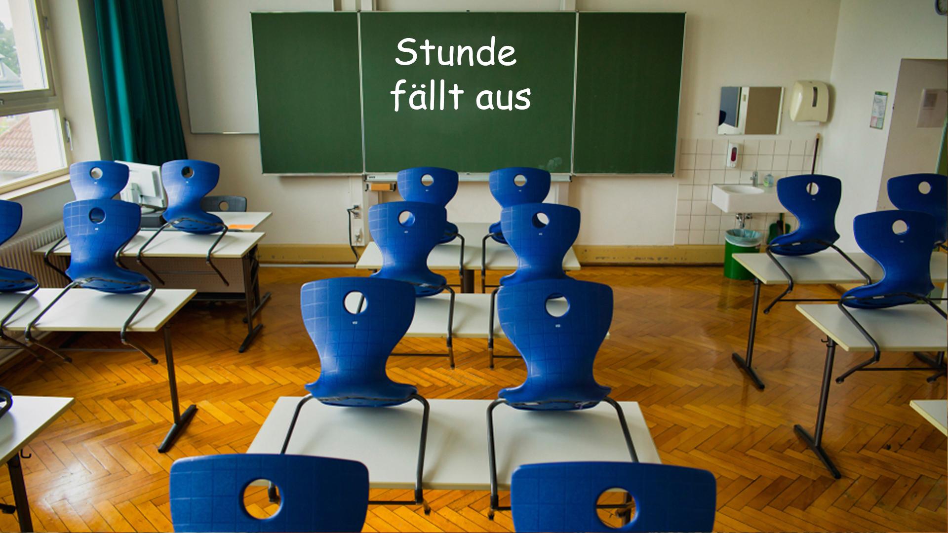 Leeres Klassenzimmer mit einer beschriebenen Tafel, auf der zu lesen ist: "Stunde fällt aus"