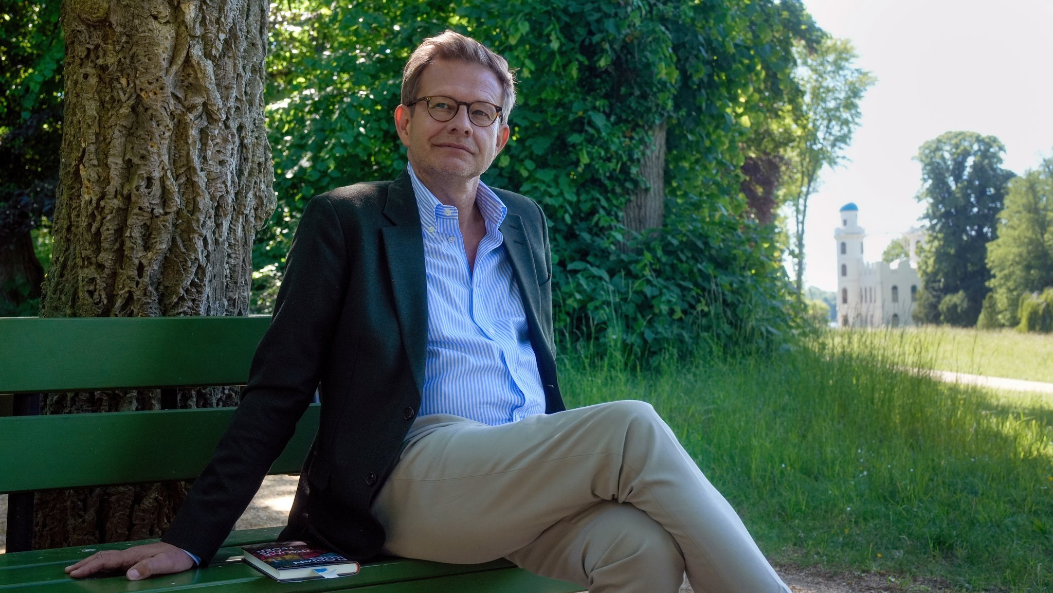 Florian Illies auf einer Bank auf der Pfaueninsel. | Bild: picture alliance/dpa | Maximilian Specht Florian Illies auf einer Bank auf der Pfaueninsel.