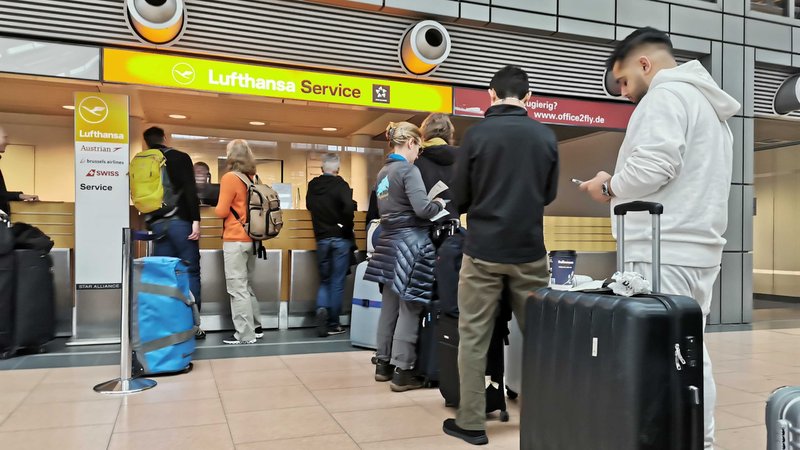 Reisende warten an einem Serviceschalter der Lufthansa. Eine IT-Panne sorgt für große Behinderungen bei der Lufthansa.