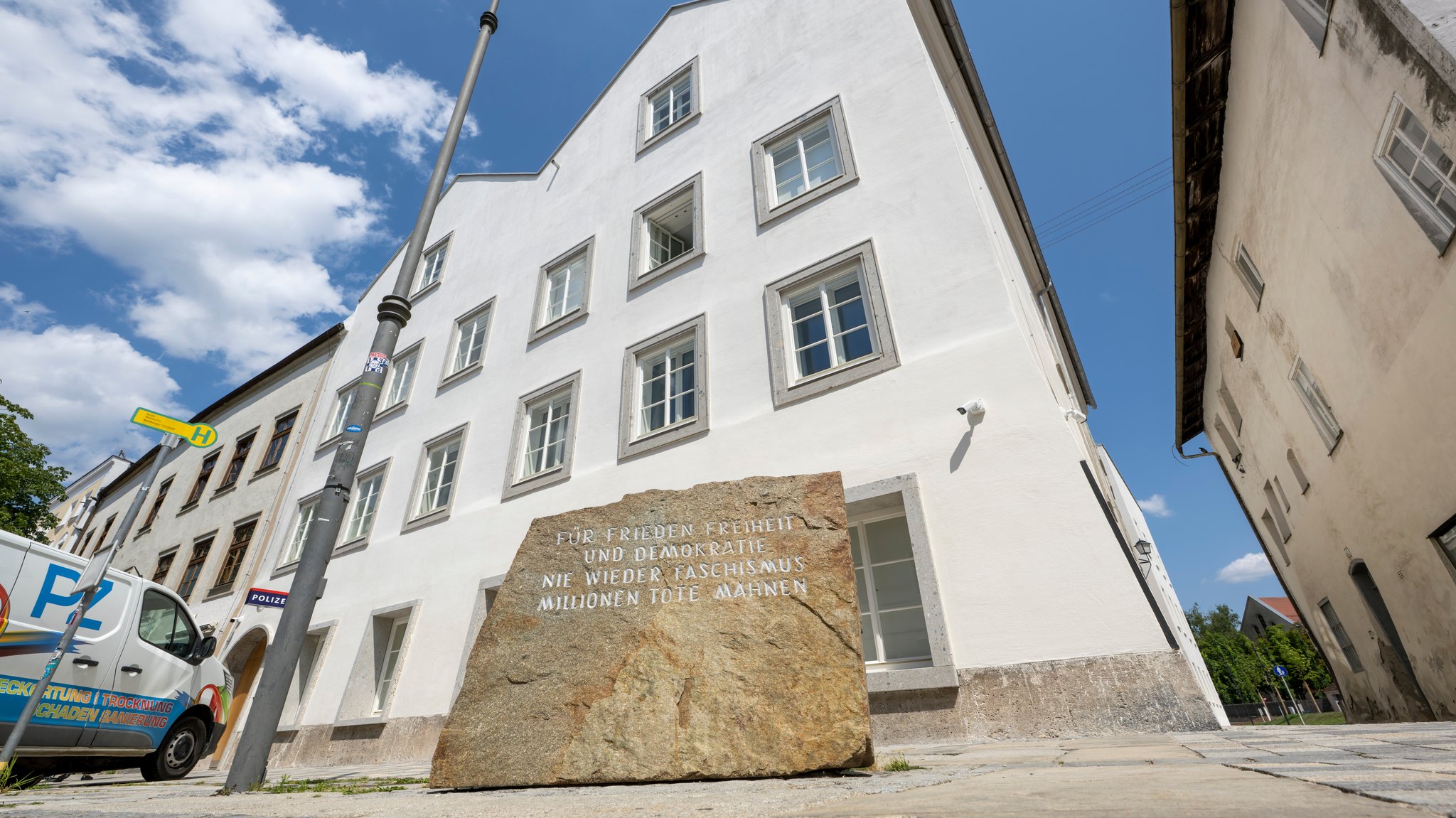Ein Stein mit der Aufschrift "Für Frieden Freiheit und Demokratie - Nie wieder Faschismus - Millionen Tote mahnen" steht vor dem neuen Polizeizentrum im Hitler-Geburtshaus. 