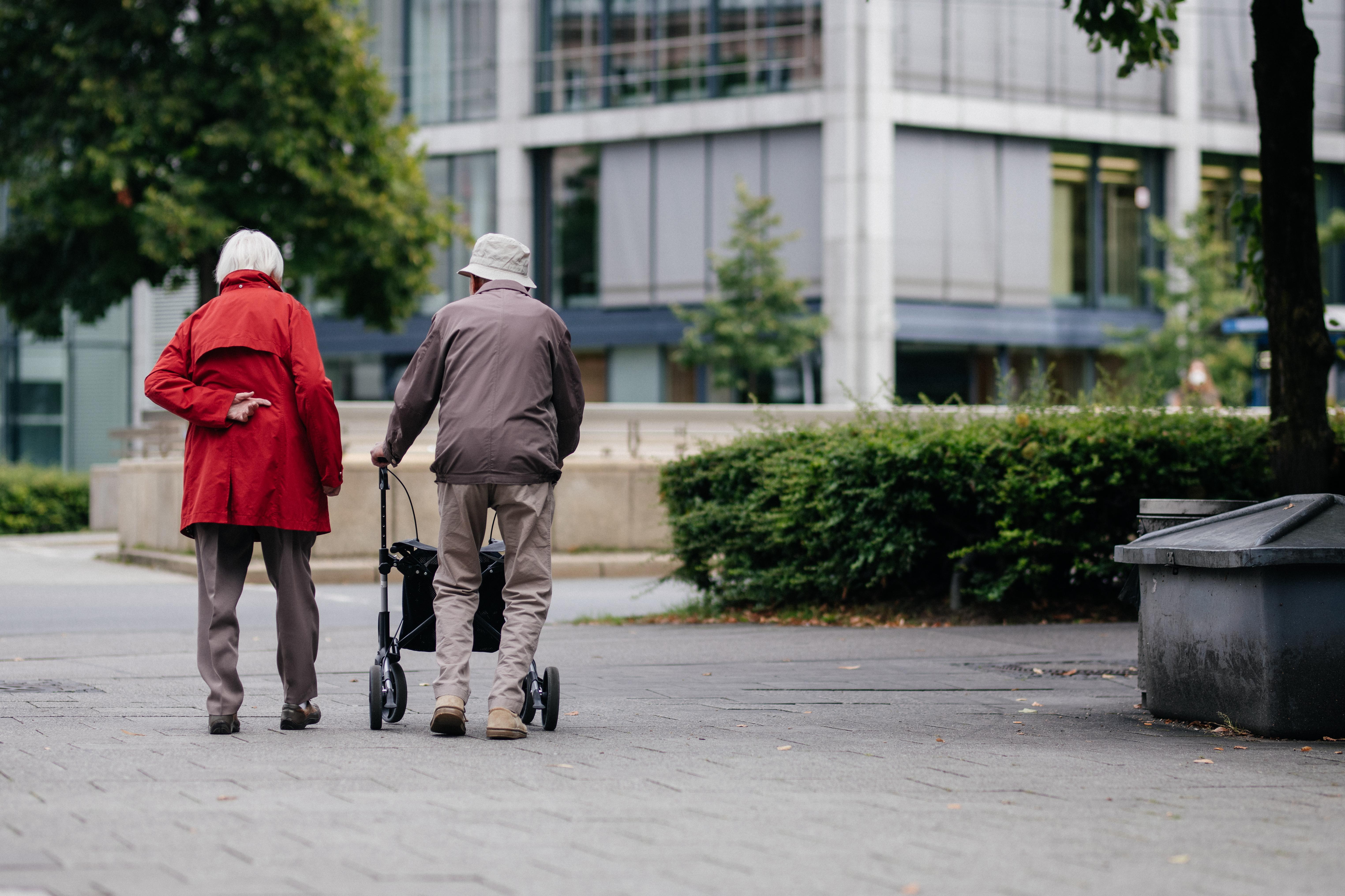 Ein Senioren Ehepaar läuft die Straße entlang.