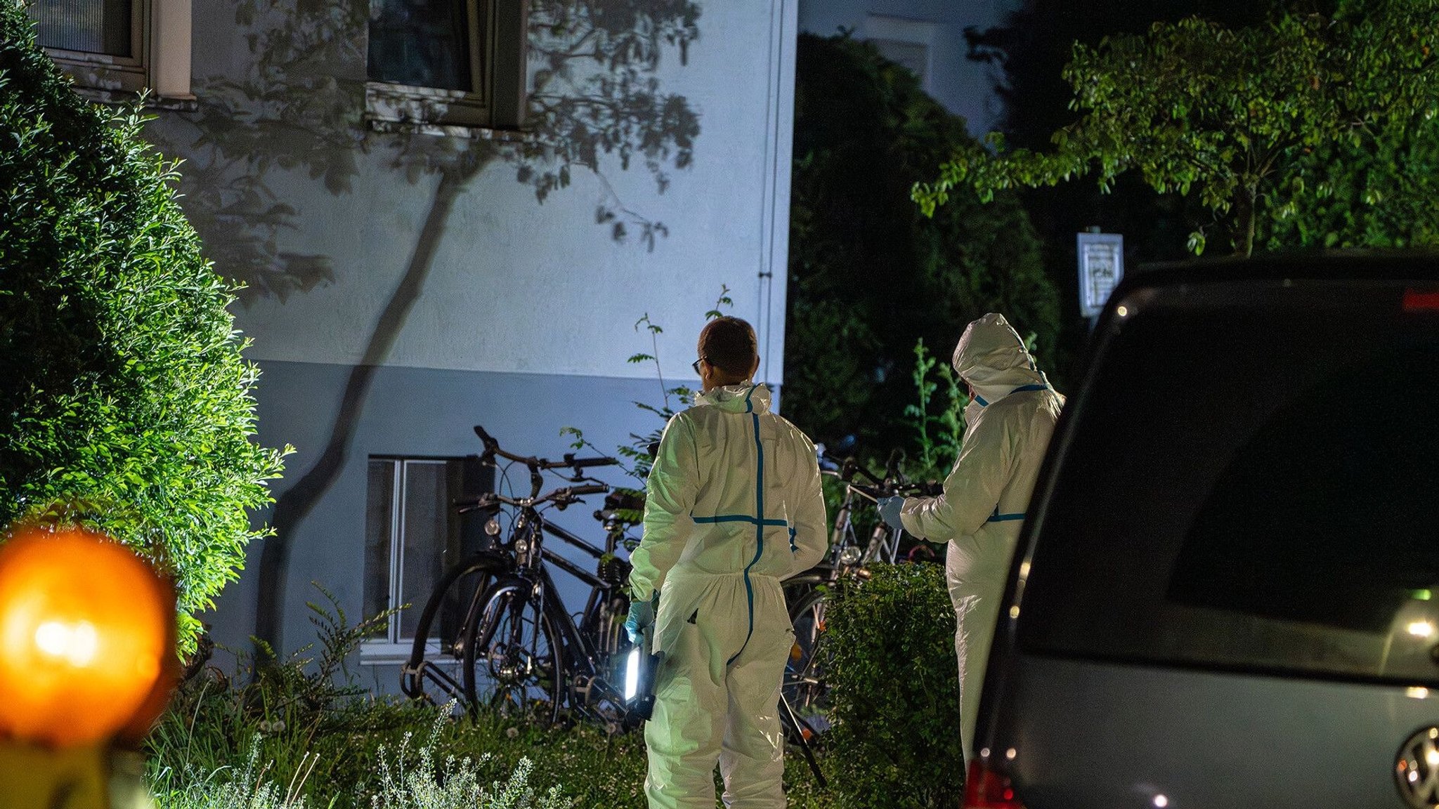 Polizisten in Schutzanzügen stehen vor einem Haus in Bamberg. | Bild: NEWS5 | Ferdinand Merzbach Polizisten in Schutzanzügen stehen vor einem Haus in Bamberg.